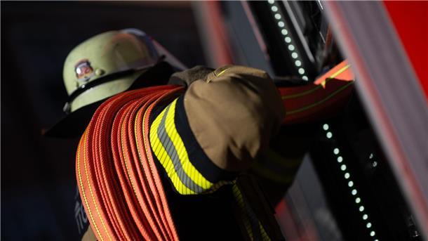 50.000 Euro Schaden bei Brand in Emsbüren Ein Feuerwehrmann nimmt einen Schlauch aus einem Einsatzfahrzeug.