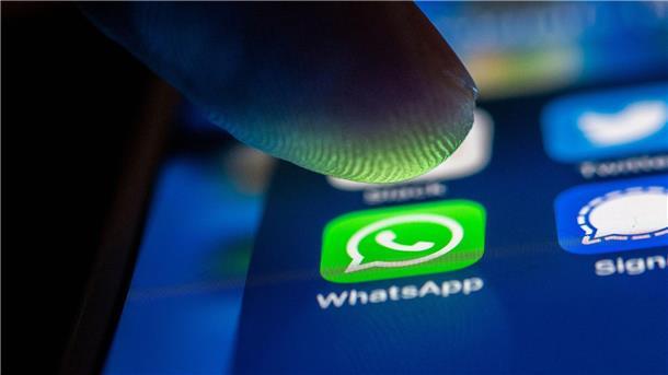 Gericht: Beleidigungen im WhatsApp-Chat - Kündigung möglich Ein Finger berührt das WhatsApp-Logo auf einem Smartphone.