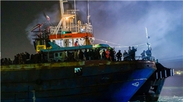 Ein Fischerboot mit etwa 500 Migranten läuft am frühen Morgen in den süditalienischen Hafen von Crotone ein.