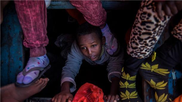Zahl der Opfer von moderner Sklaverei stark gestiegen Ein Flüchtlingskind aus Eritrea versucht an der Küste zu Libyen, an Bord eines überfüllten Holzbootes hinaufzuklettern.