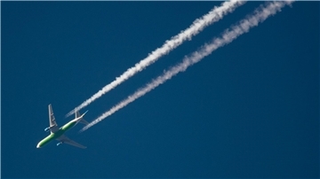Ein Flugzeug hinterlässt Kondensstreifen am Himmel. Spätestens Mitte des Jahrhunderts soll schließlich mit grünem Wasserstoff geflogen werden.