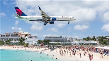 Dürfen Schüler auf Klassenfahrt fliegen? Flugzeug über einem Strand.