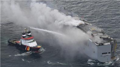 Ein Foto, das von einem Flugzeug der niederländischen Küstenwache aufgenommen wurde, zeigt den brennenden Frachter «Fremantle Highway» in der Nordsee. Der deutsche Notschlepper «Nordic» schießt Wasser auf den Rumpf, um die Bordwand zu kühlen.