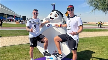 Patrick Temmen (links) und Dennis Jesionek mit dem Maskottchen der Fußball-WM 2022.