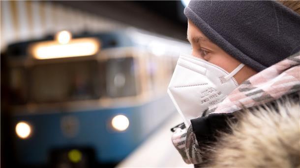 RKI: Corona-Neuinfektionen und Inzidenz steigen an Ein Frau mit FFP2-Maske wartet auf die Bahn.