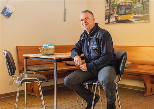 Busfahrer Pjer Ortmann im Pausenraum an der Haltestelle "Heinrich-Plett-Straße" in Leherheide: Er sitzt auf einem Stuhl an einem Tisch.