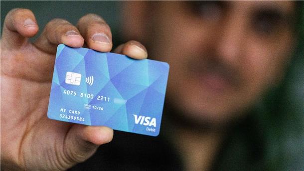 Ein Geflüchteter mit einer Debitcard.