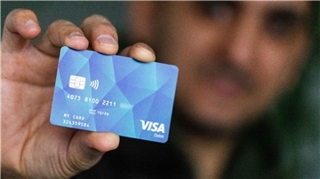 Ein Geflüchteter mit einer Debitcard.