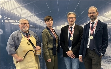 Gruppenfoto : drei Herren und eine Frau mit kurzen Haaren gucken in die Kamera