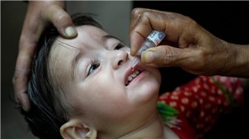 Ein Gesundheitshelfer verabreicht einem Kind einen Polio-Impfstoff.