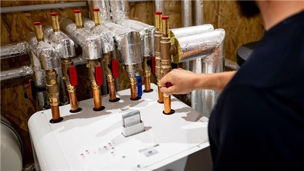 Ein Handwerker arbeitet an einer Wärmepumpe in der Enpal Akademie.