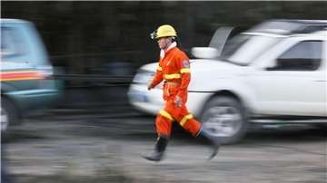 Ein Helfer eines Rettungsdienstes läuft bei einem Einsatz nach einem Grubenunglück.