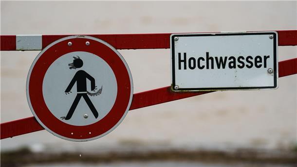 Wegen des Hochwassers: Lilienthal sperrt Wälder Ein Hochwasser-Schild steht an einem überfluteten Feld.