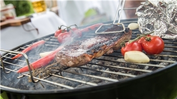 Grillgut liegt auf einem Holzkohlegrill.