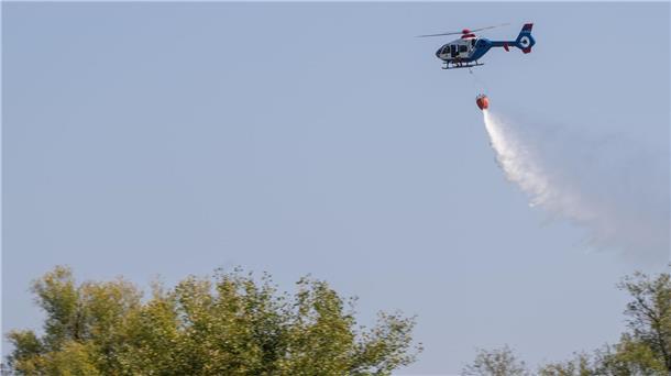 Ein Hubschrauber der Polizei wirft bei einer Übung zur Waldbrandbekämpfung Löschwasser ab.