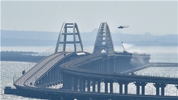 Ein Hubschrauber wirft Wasser ab, um ein Feuer auf der Krim-Brücke, die das russische Festland und die Halbinsel Krim über die Meerenge von Kertsch verbindet, zu löschen.