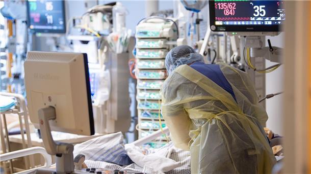 Corona: RKI meldet Anstieg der Inzidenz auf 264,6 Ein Intensivpfleger steht auf der Intensivstation eines Krankenhauses neben einem Covid-19-Patienten.