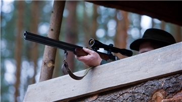 Ein Jäger zielt mit seinem Gewehr. 