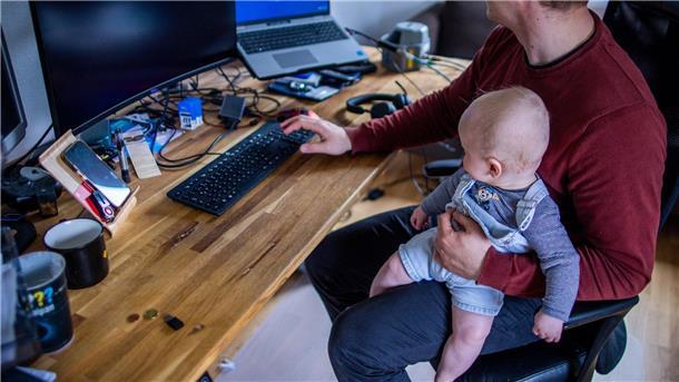 Väter verbringen eineinhalb Stunden mit ihren Kindern Ein junger Vater im Home-Office mit seinem sechs Monate alten Sohn.