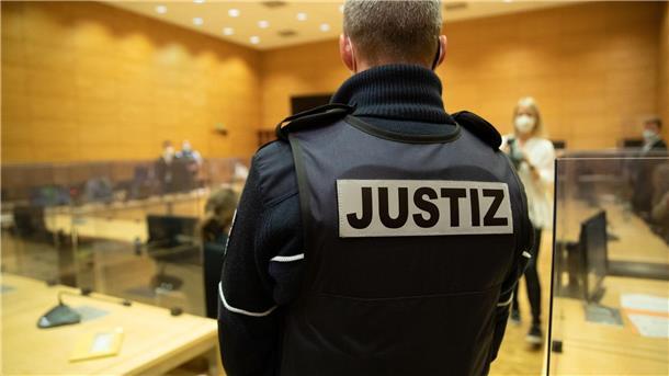 Ein Justizbeamter steht in einem Gerichtssaal.
