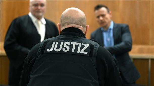 Ein Justizbeamter steht vor den Anwälten der Angeklagten.