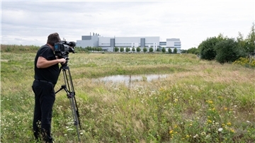 Ein Kameramann auf einer Wiese im Dresdner Stadtteil Klotzsche: In der Nähe der  Halbleiterfabrik von Bosch will auch der taiwanische Chiphersteller TSMC eine Fabrik errichten.