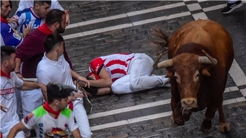 Ein Kampfstier läuft am dritten Tag des Stiertreibens während des „Sanfermines“-Fest zwischen den Menschen umher.