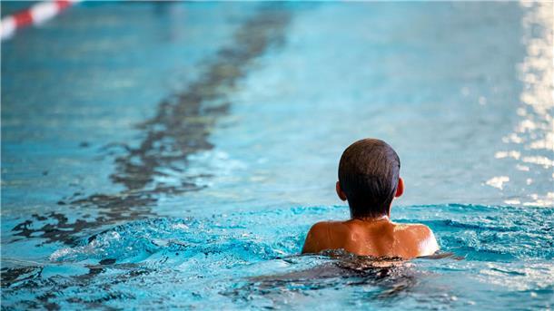 Ein Kind schwimmt in einem Schwimmbad.