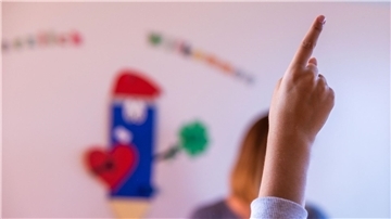 Ein Kind zeigt im Unterricht, dass es etwas sagen will. Eine Umfrage zeigt, dass viele Kinder ihren Alltag mitgestalten wollen.