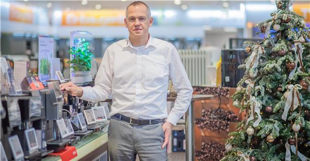 Ein Mann steht in einem Elektronik-Fachmarkt vor einem Regal mit Kaffeevollautomaten