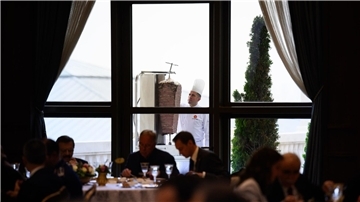 Ein Koch bereitet auf einer Terrasse des Präsidialpalasts Dönerfleisch vom Spieß zu.