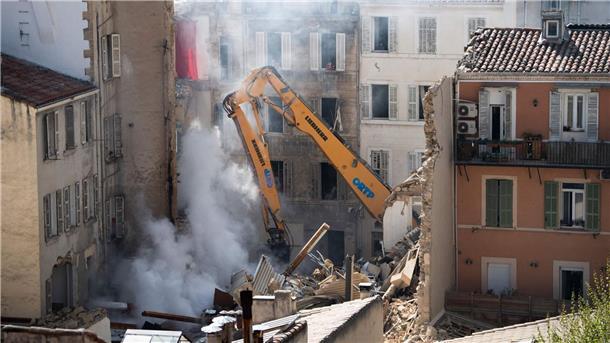Haus in Marseille stürzt ein - Sechs Tote in Trümmern Ein Kran bewegt Schutt eines eingestürzten Gebäudes in der Innenstadt von Marseille.
