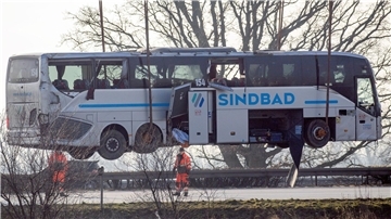 Ein Kran hebt den verunglückten Reisebus zurück auf die Fahrbahn.