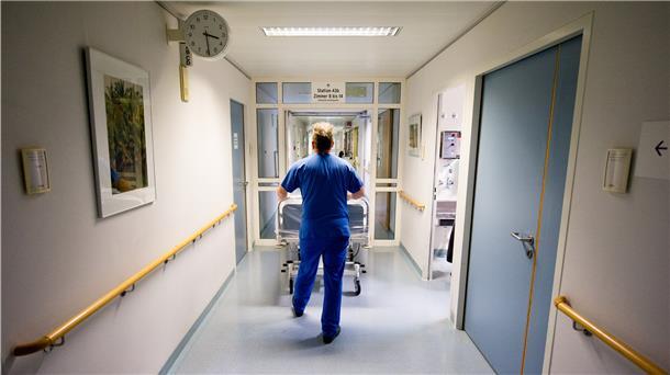 Ein Krankenpfleger schiebt in einer Klinik ein Krankenbett durch den Flur. Pflegekräfte leiden derzeit unter Personalmangel in ihren Einrichtungen.
