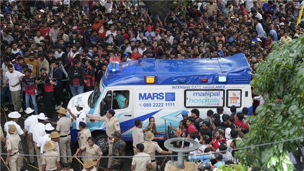 Mindestens elf Tote nahe Kricket-Stadion in Indien Ein Krankenwagen bahnt sich den Weg durch eine Menschenmenge am M. Chinnaswamy-Stadion in der indischen Stadt Bengaluru.