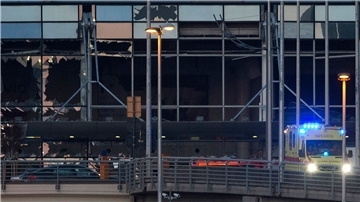 Ein Krankenwagen fährt im März 2016 an der zerstörten Fassade des Terminals des Flughafens Zaventem vorbei.