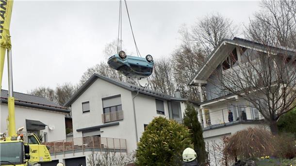 Auto landet auf Terrasse - zwei Schwerverletzte Ein Kranwagen hebt den verunglückten Kleinwagen von der Terrasse und dem Garten eines Einfamilienhauses in Gummertsbach.