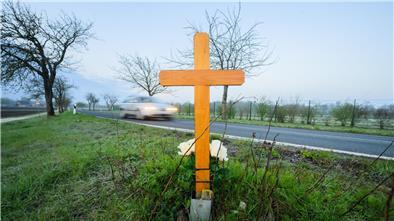 Ein Kreuz zum Gedenken an ein 21-jähriges Opfer eines Verkehrsunfalls steht an einer Landstraße.