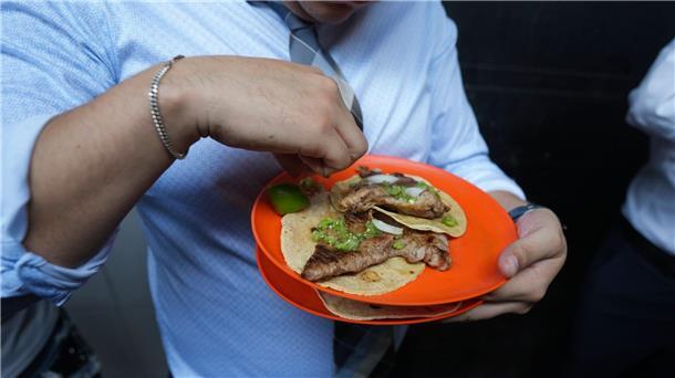 Ein Kunde drückt Limettensaft auf seine Tacos.