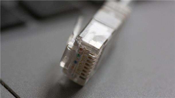 „Recht auf schnelles Internet“: Behörde schreitet ein Ein LAN-Kabel liegt auf einem Computerlaptop.