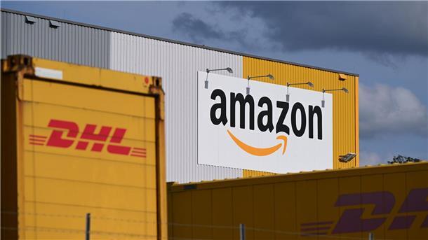 Ein Logistikzentrum von Amazon, auf dessen Gelände DHL-Container stehen. DHL ist das größte Paketunternehmen in Deutschland, gefolgt von Amazon - der Online-Handelsriese trägt einen großen Teil bei ihm bestellten Waren selbst aus. (Archivbild)