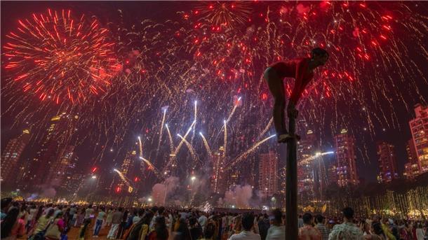 Bilder des Tages Ein Mädchen performt auf einer Mallakhamb-Stange, während Feuerwerkskörper den Himmel während des Diwali-Lichterfestes in Mumbai erhellen.