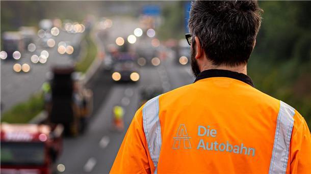 Ein Mann beobachtet Arbeiten auf einer Autobahn.