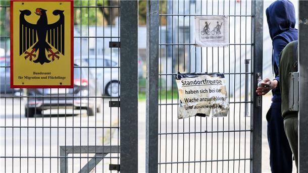 Ein Mann betritt neben einem Schild vom Bundesamt für Migration und Flüchtlinge die Landesaufnahmebehörde Niedersachsen am Standort Braunschweig.