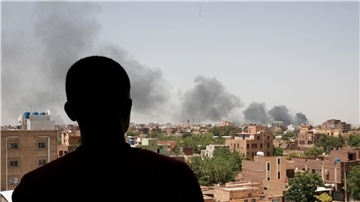 Ein Mann blickt auf die Stadt Khartum, wo schwarzer Rauch aufsteigt. Seit nun mehr vier Monaten bekämpfen sich die Konfliktparteien im Sudan.