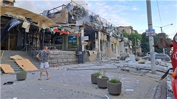Ein Mann blickt in Kramatorsk auf eine Ladenzeile, die durch einen russischen Angriff zerstört wurde.