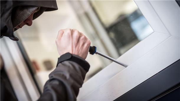 Ein Mann demonstriert in einer polizeilichen Beratungsstelle, wie Einbrecher Fenster aufhebeln. (Illustration)