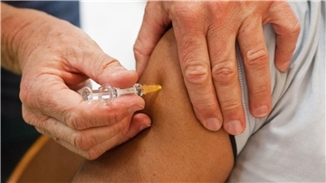Ein Mann erhält eine Impfung gegen Grippe, Tetanus, Diphtherie, Keuchhusten (Pertussis) und Polio.