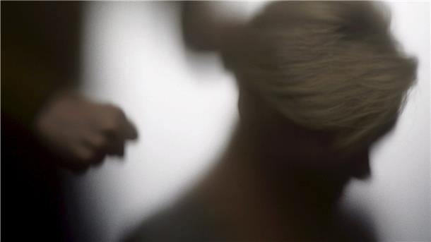 Es ist die Silhouette einer Frau zu sehen und hinter ihr die Hand einer weiteren Person, die sich zur Faust ballt.