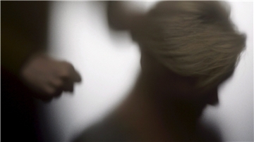 Es ist die Silhouette einer Frau zu sehen und hinter ihr die Hand einer weiteren Person, die sich zur Faust ballt.